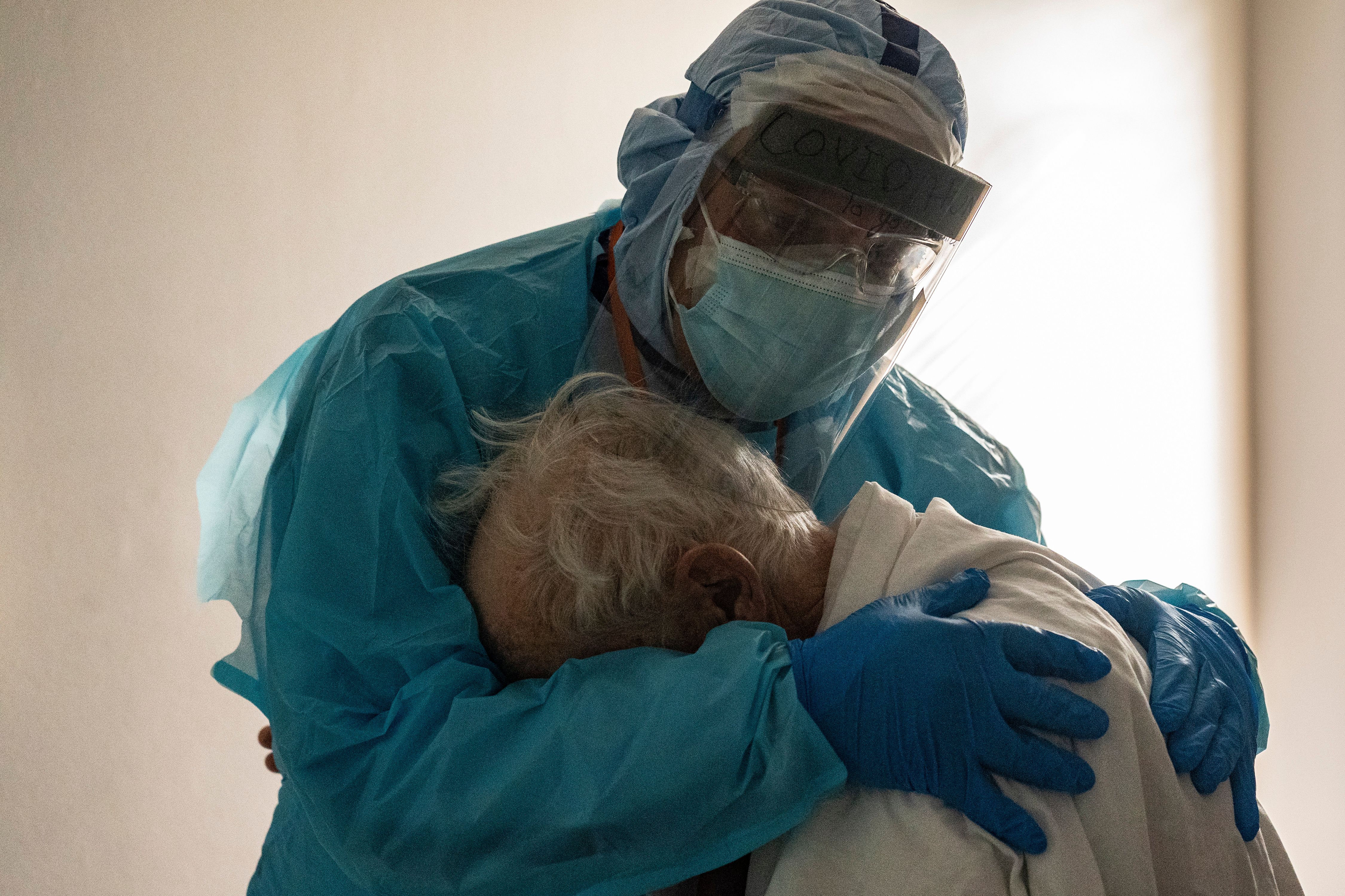A doctor comforts a COVID-19 patient.