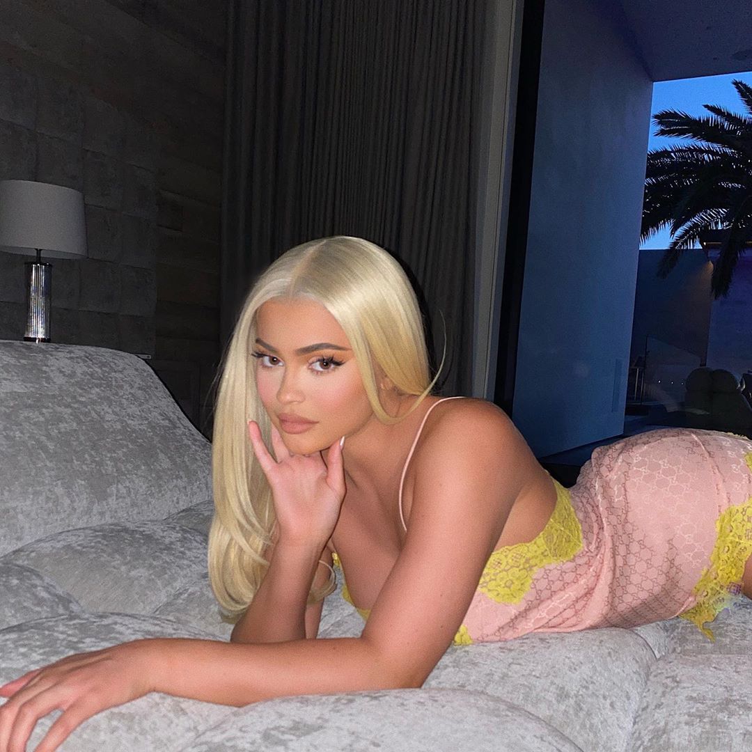 Kylie Jenner poses on a bed in a Gucci nightie