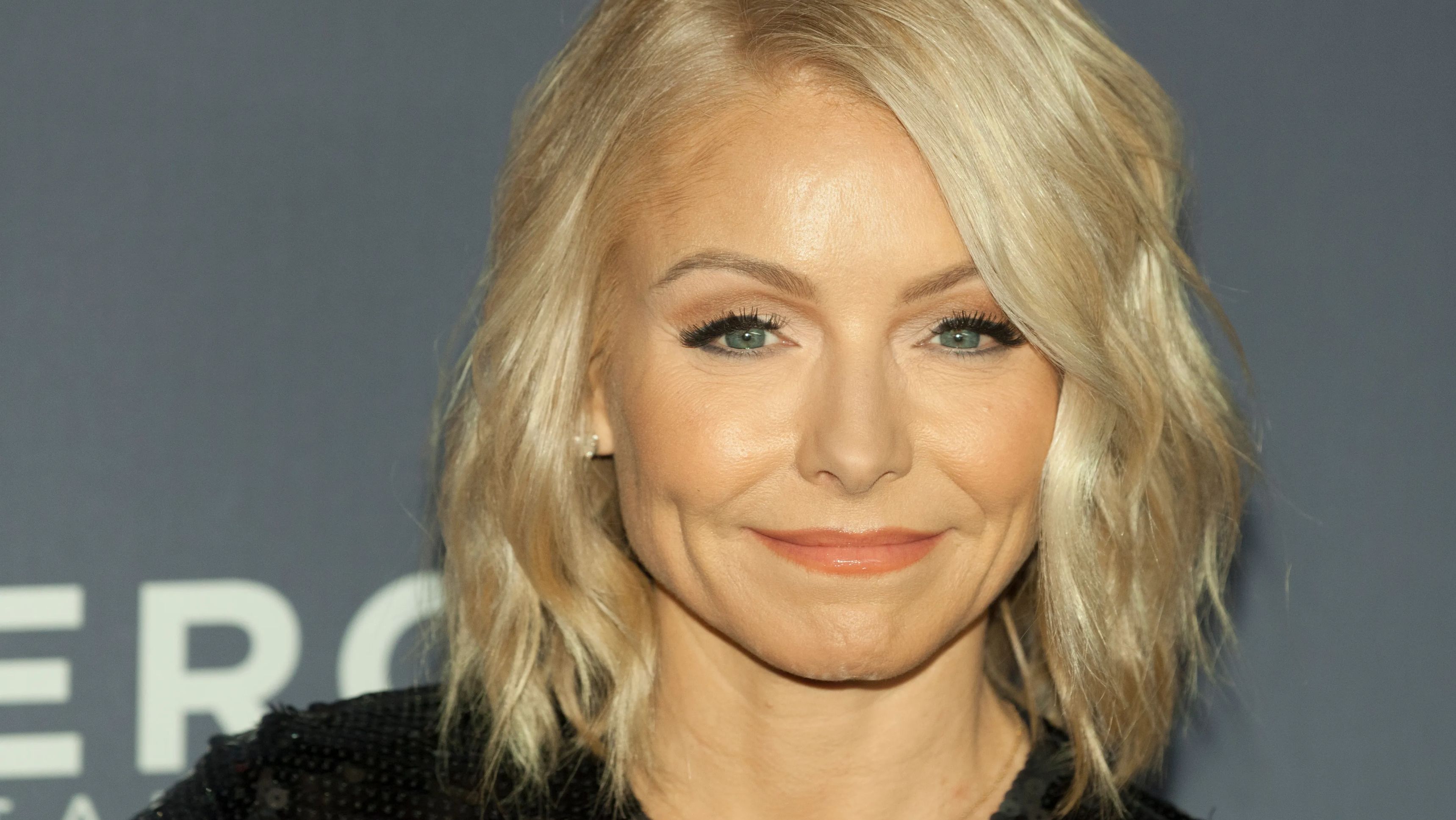 Close-up of a smiling Kelly Ripa wearing a black sequined dress at an event.