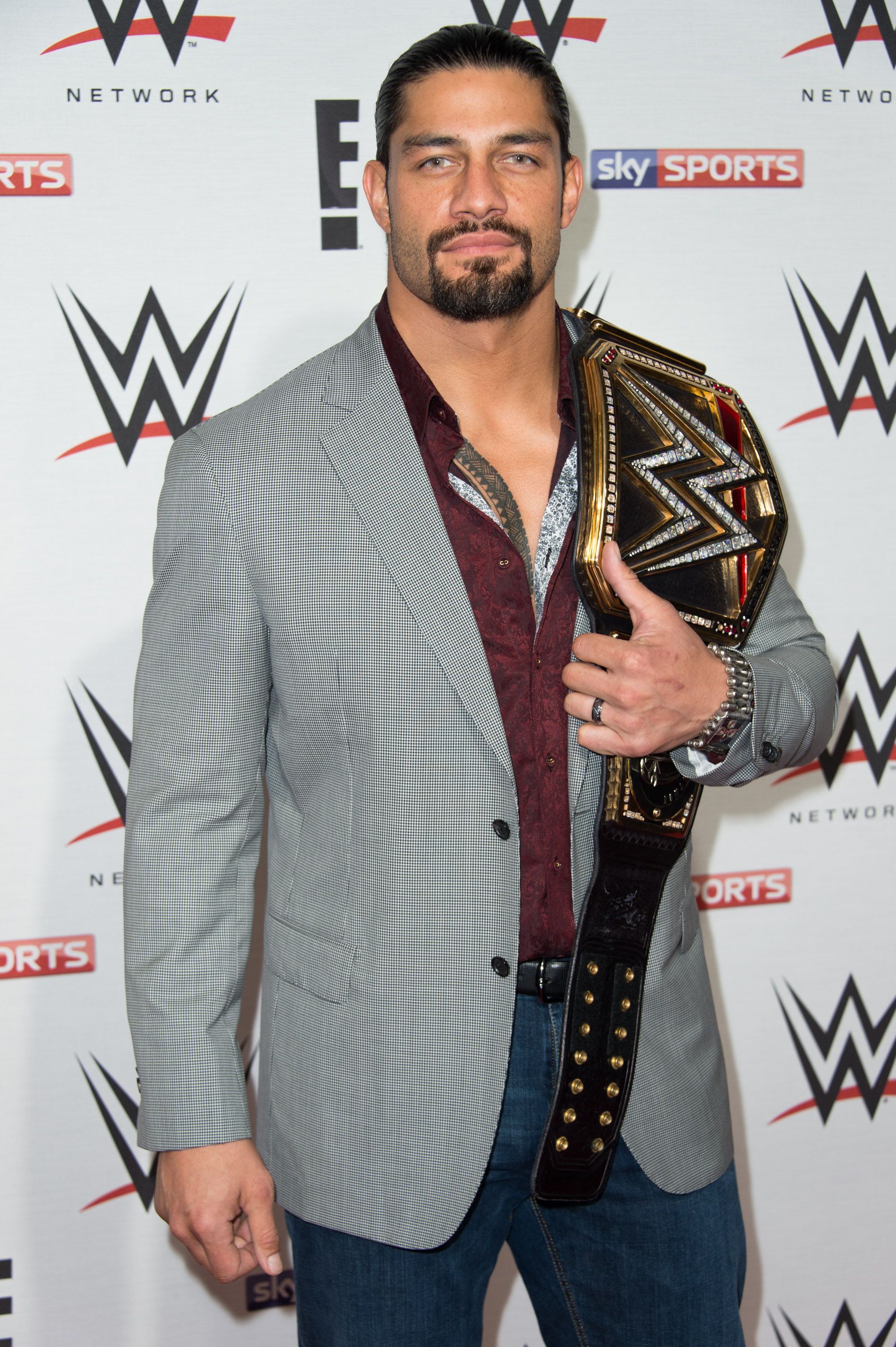 Roman Reigns holding his WWE belt