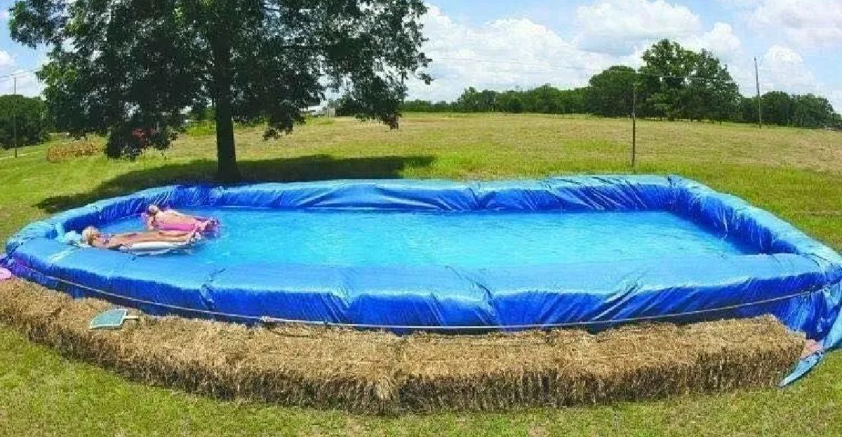 two people relaxing in a hay bale swimming pool on s sunny day