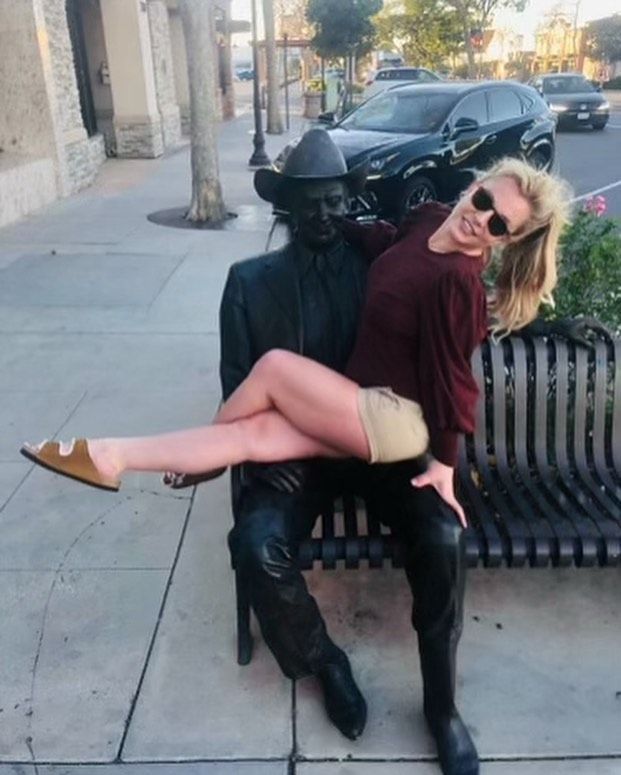 Britney Spears poses by a statue