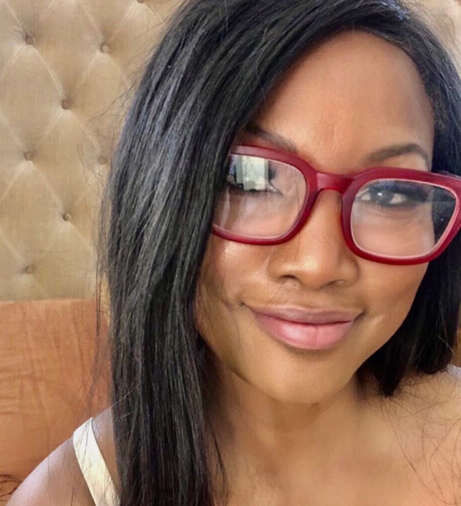 Garcelle poses with red reading glasses.