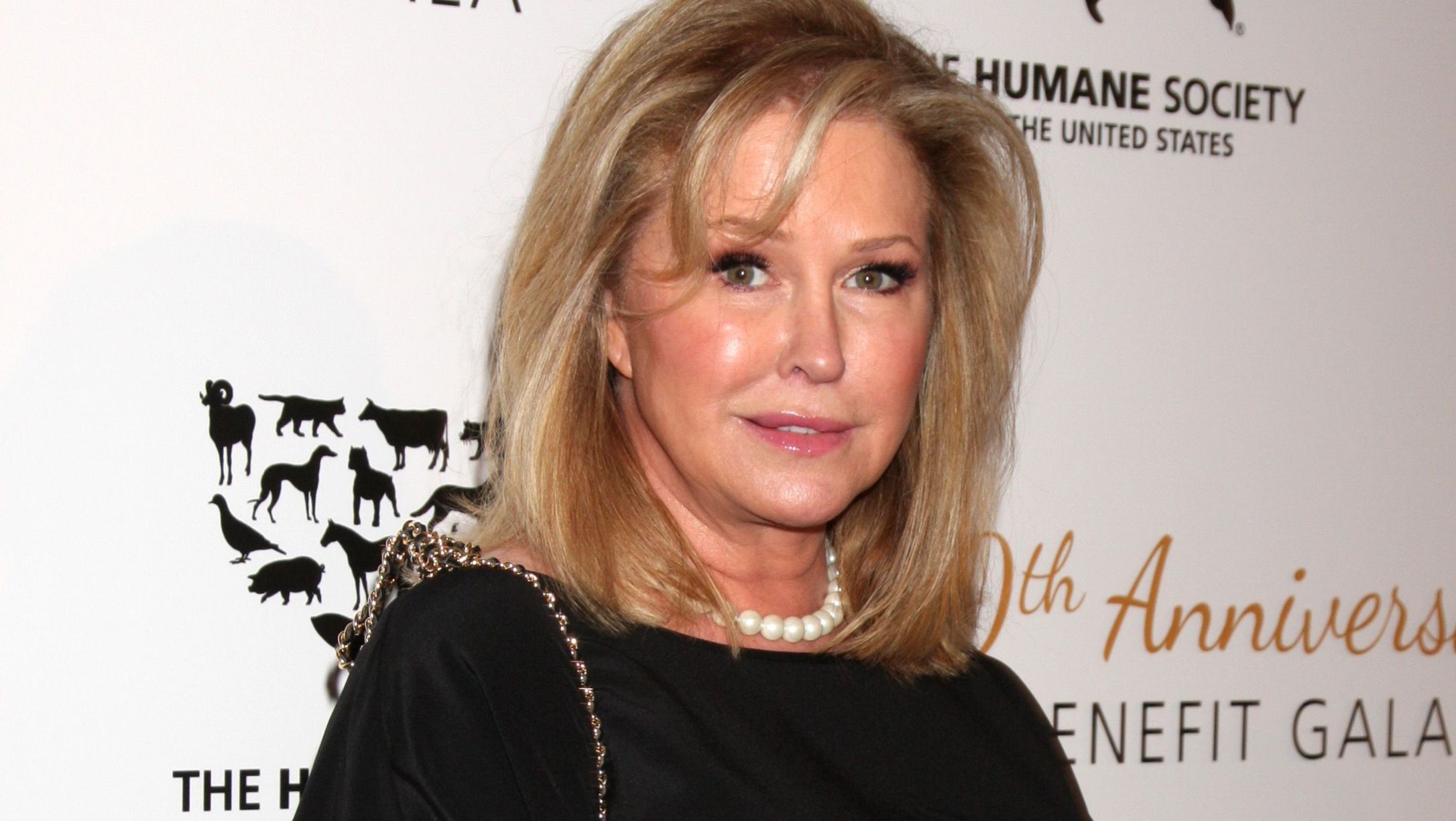 Kathy Hilton wears a pearl necklace and black dress.