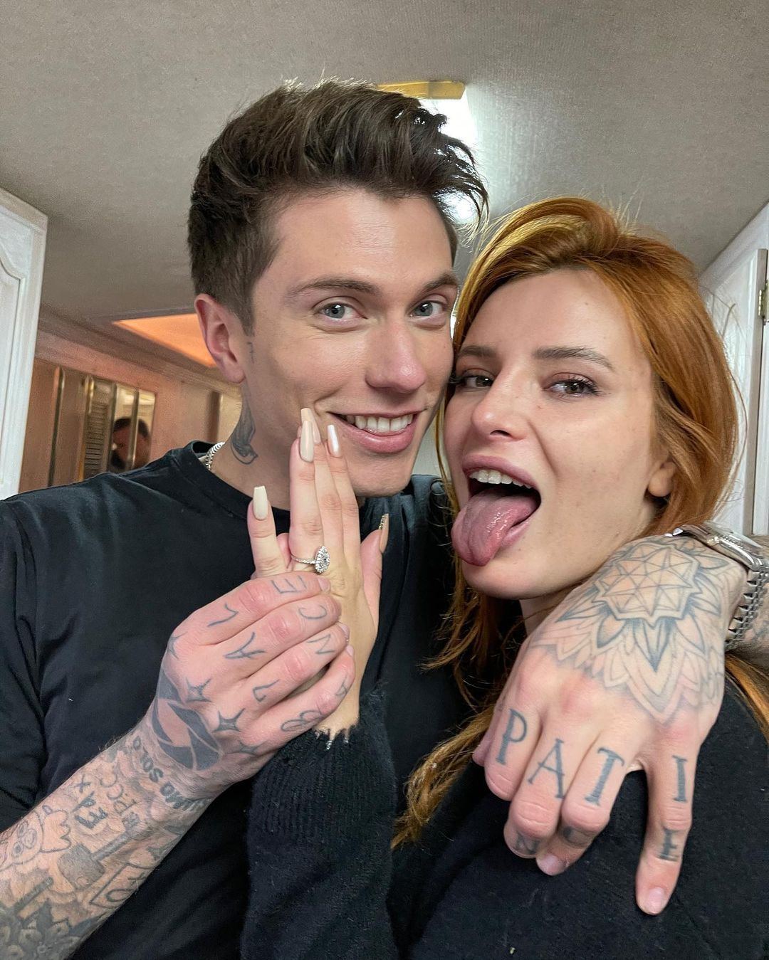 Bella Thorne sticks her tongue out and shows off engagement ring while Benjamin Mascolo puts his arm around her.