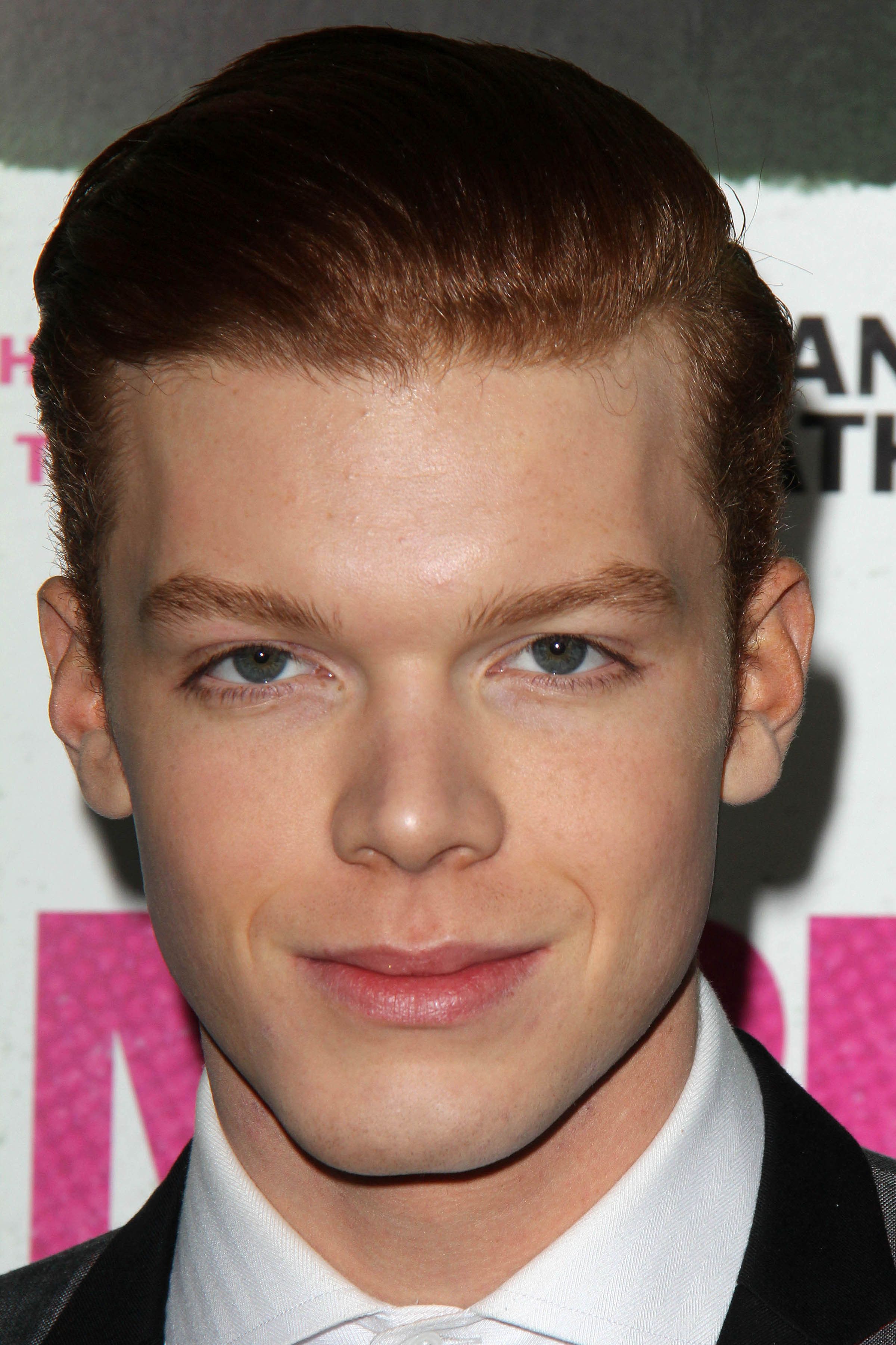Cameron Monaghan smiles in a white collared shirt and blazer.