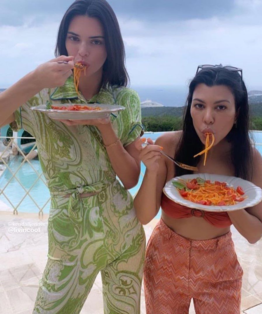 Kendall and Kourtney eating pasta while on vacation
