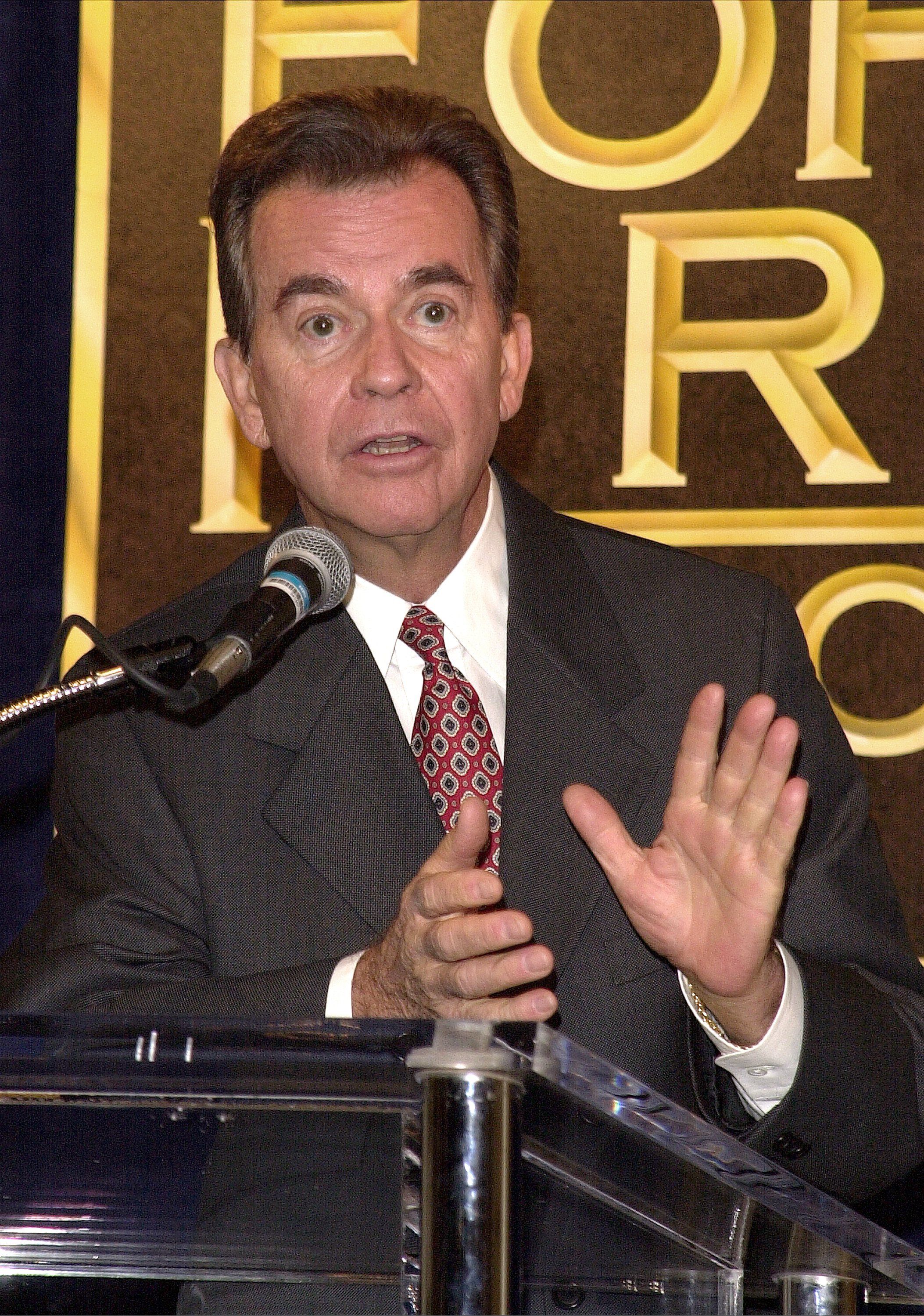 Dick Clark looks surprised with his hands preparing to clap.