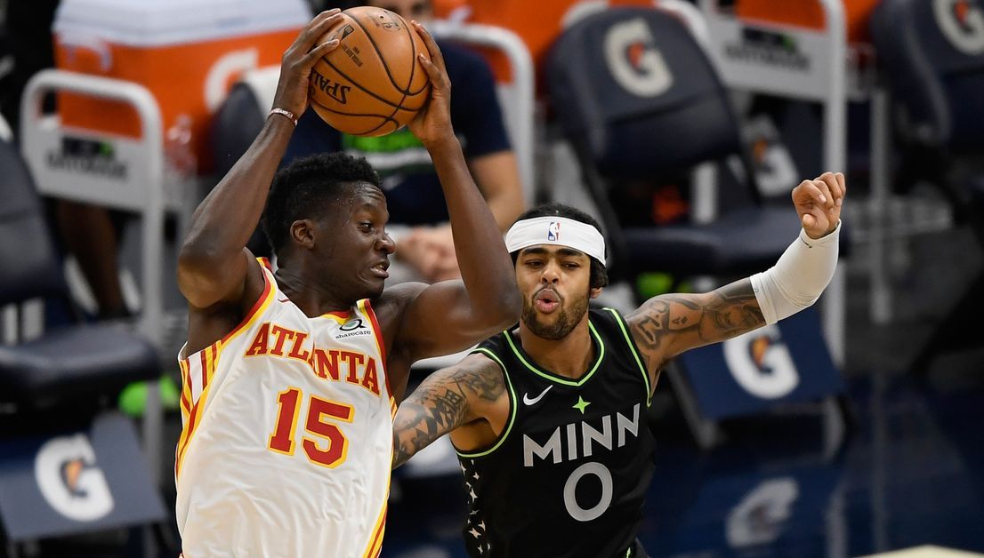 Clint Capela of the Atlanta Hawks protects the ball from D'Angelo Russell of the Minnesota Timberwolves.