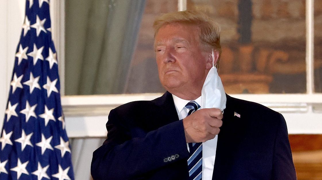 Former President Donald Trump takes off his face mask.