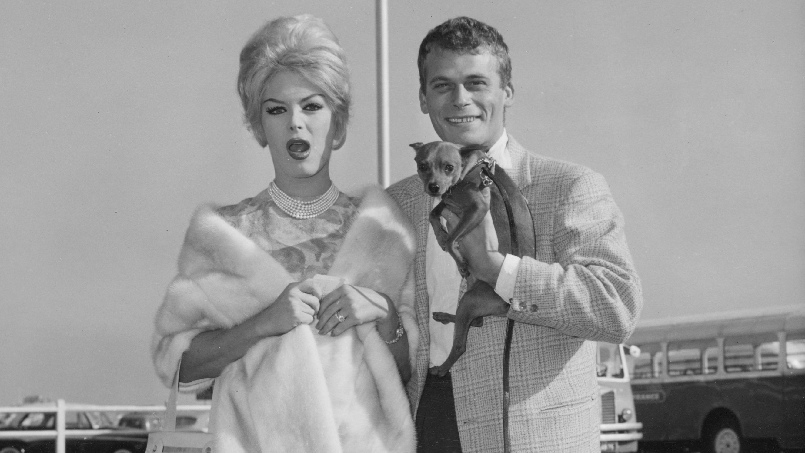A couple is seen holding a dog in the 1960s.