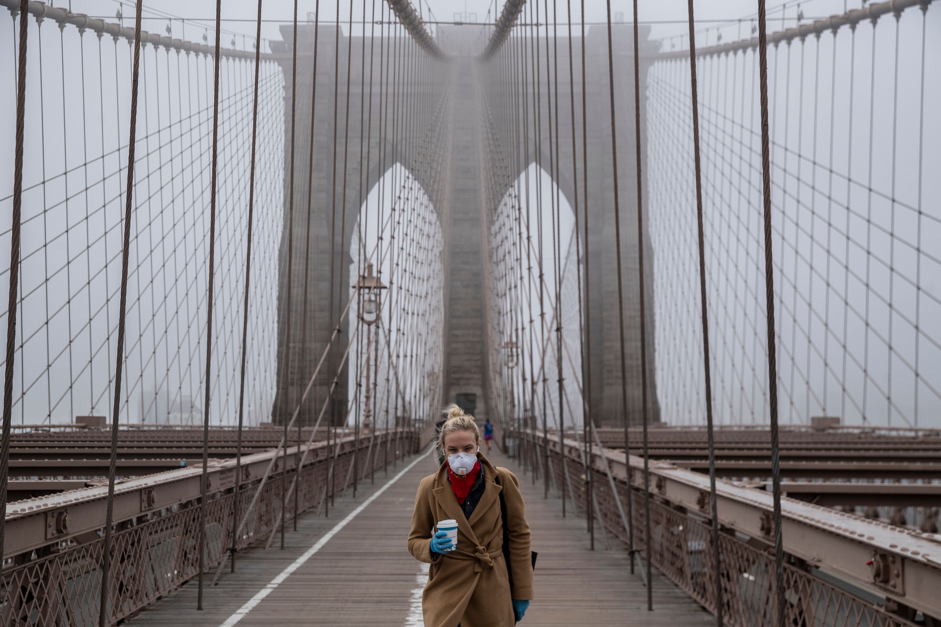 A person walks on the Brooklyn Bridge.