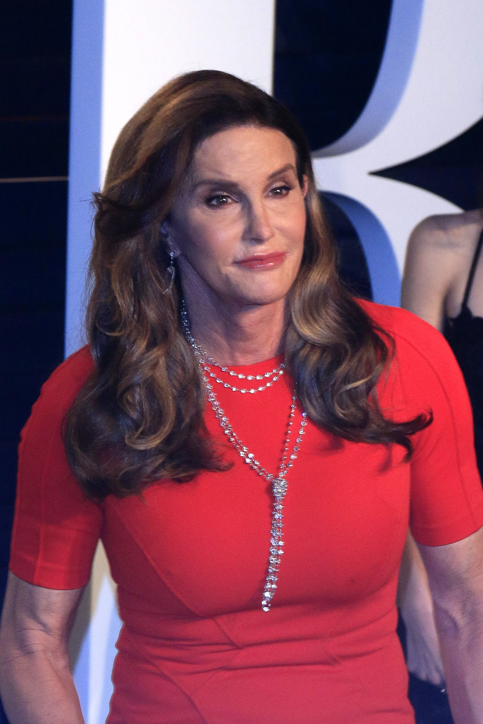 Caitlyn Jenner wears a red dress and diamond necklace.