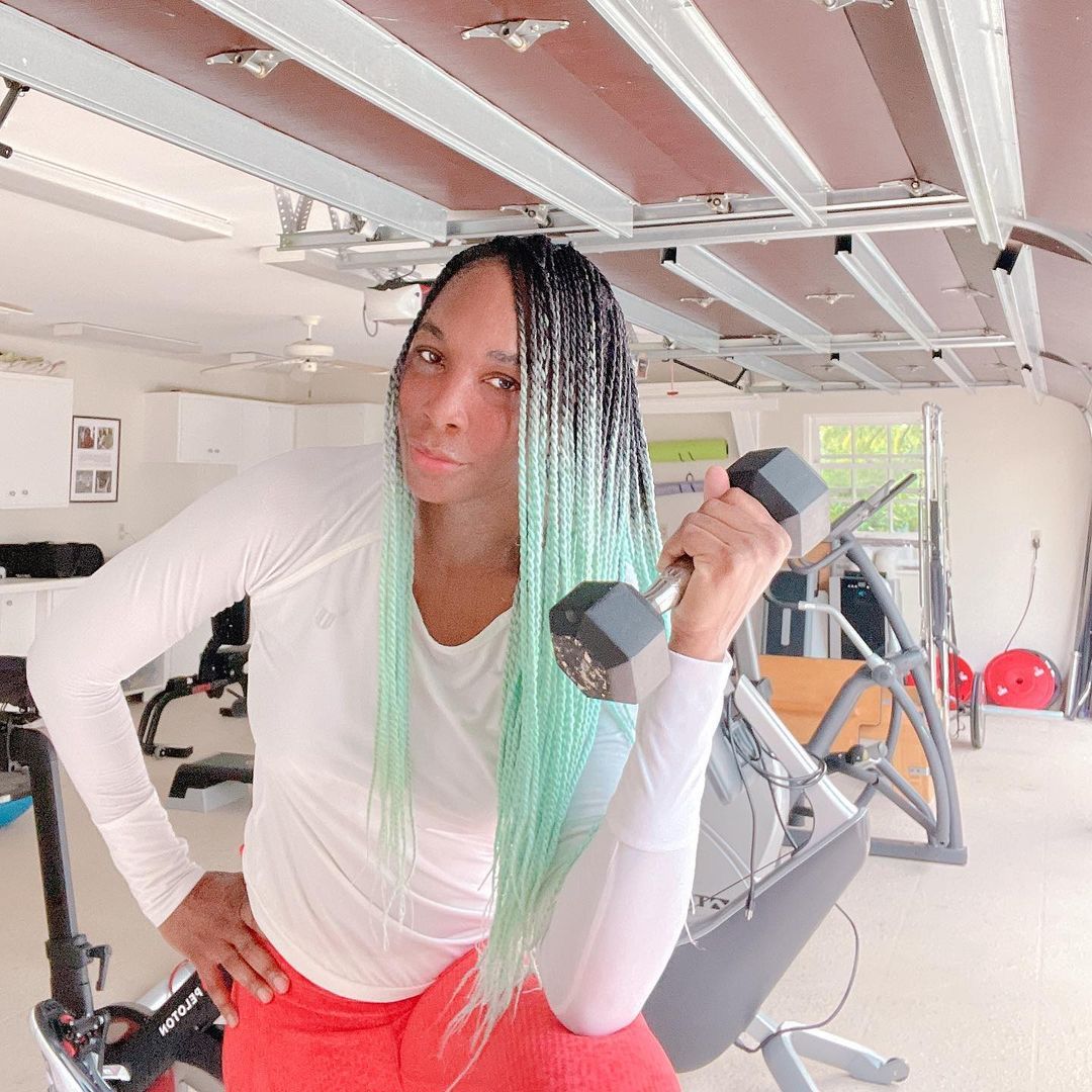 Venus Williams holds up a dumbbell in her home gym.