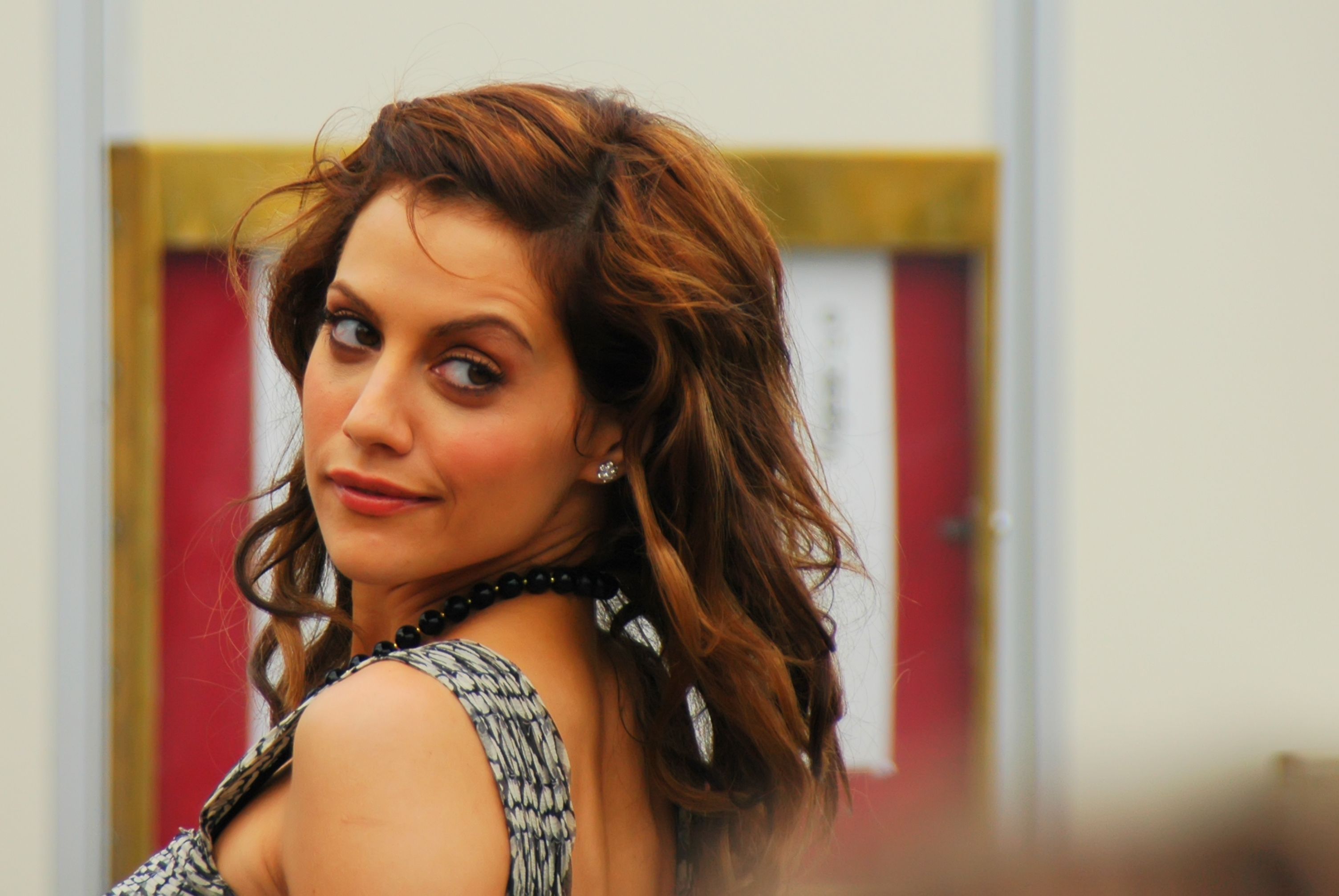 Brittany Murphy looks over her shoulder with a smirk in close-up photo. 