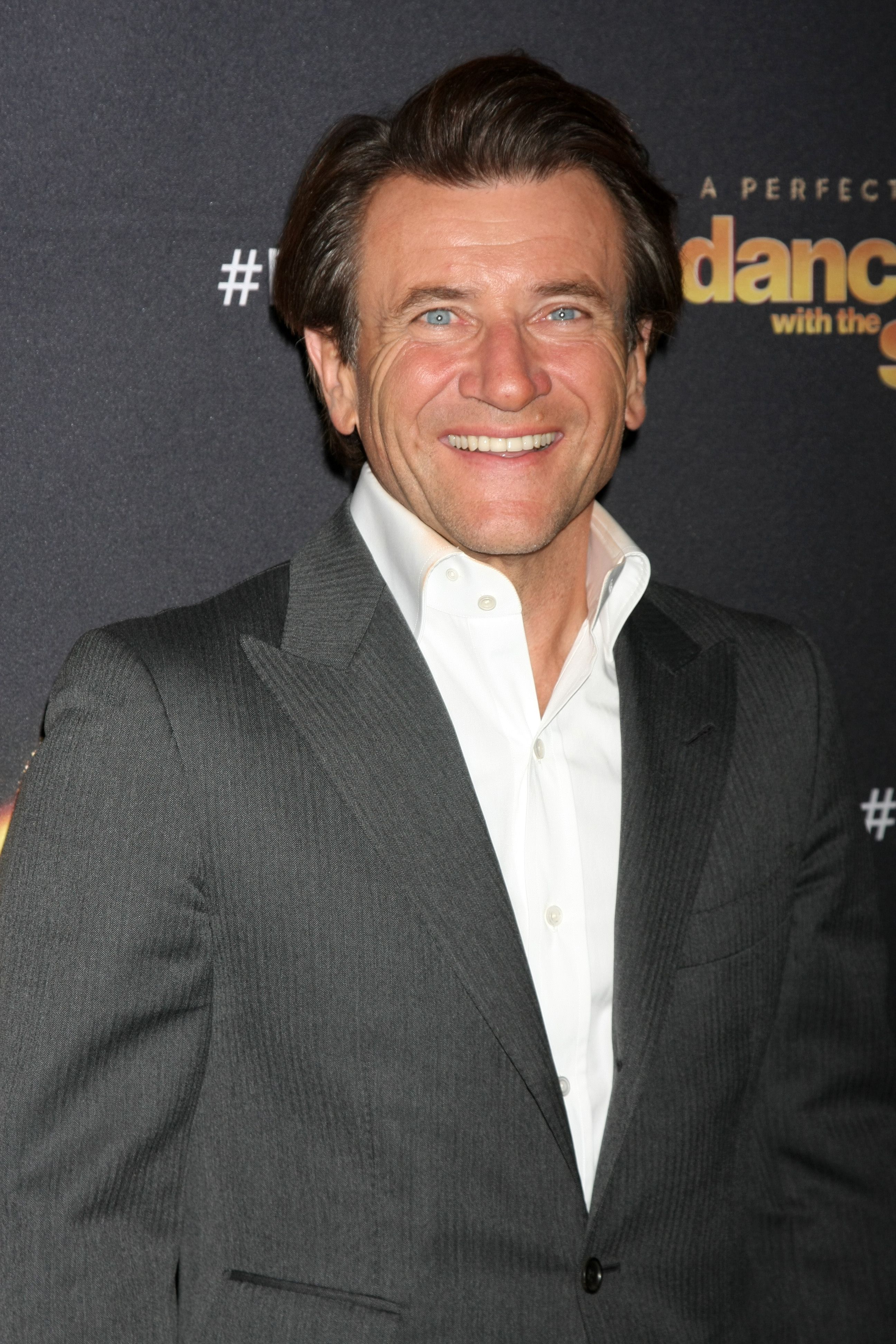 Robert Herjavec wears a gray suit and white button-up.