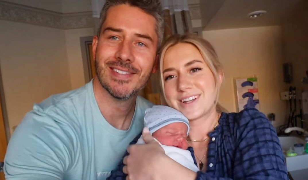 Arie and Lauren pose with one of their newborns