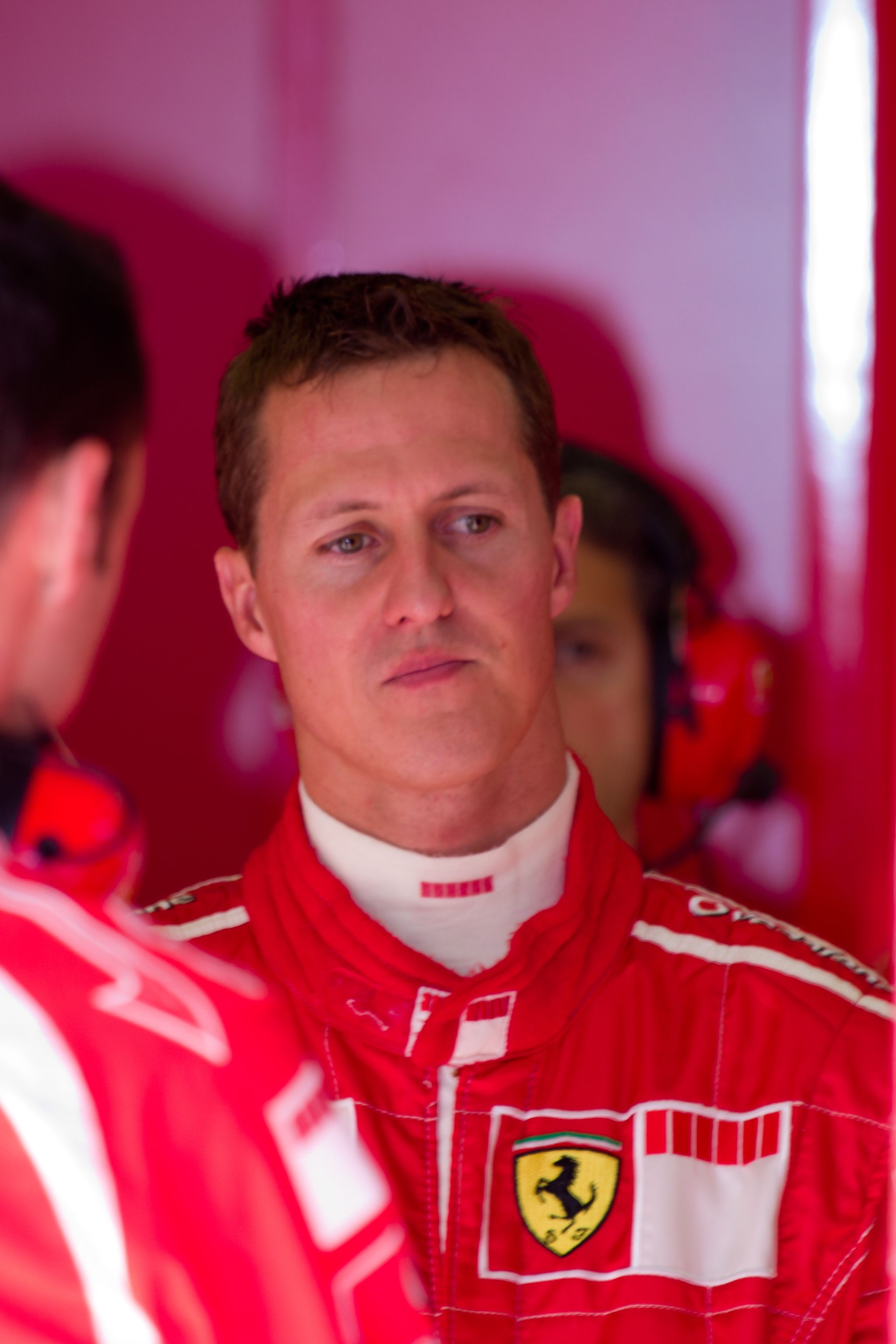 Michael Schumacher wears a red race car driver outfit.