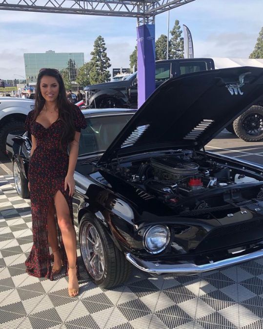 Constance Nunes stands beside a Shelby Mustang.