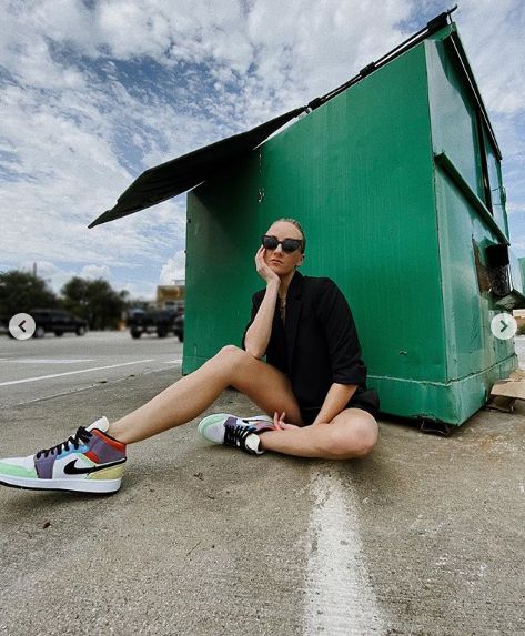 Nastia Liukin poses leggy by a dumpster