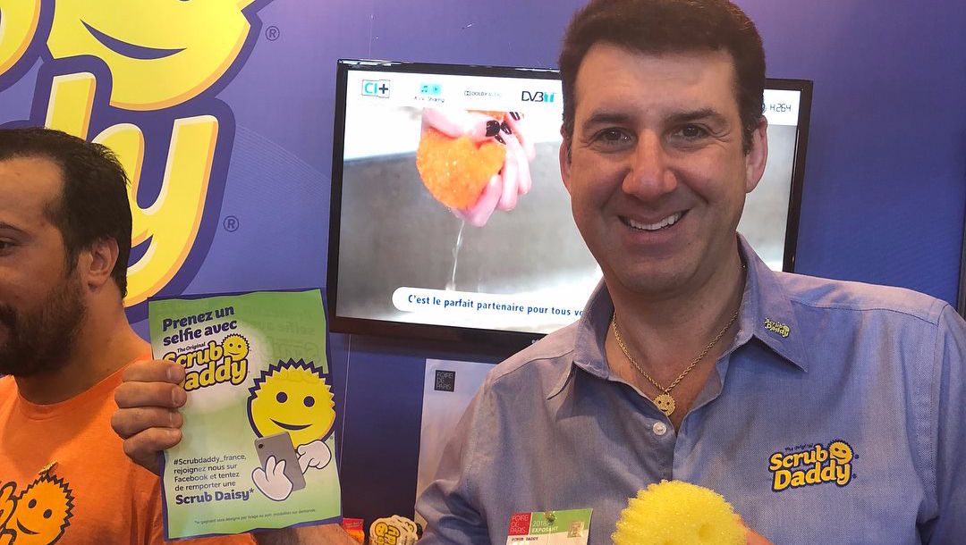 Scrub Daddy exec smiles with product.