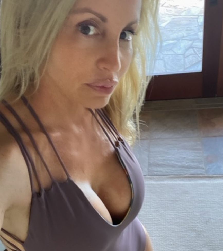Camille Grammer poses in a one-piece.