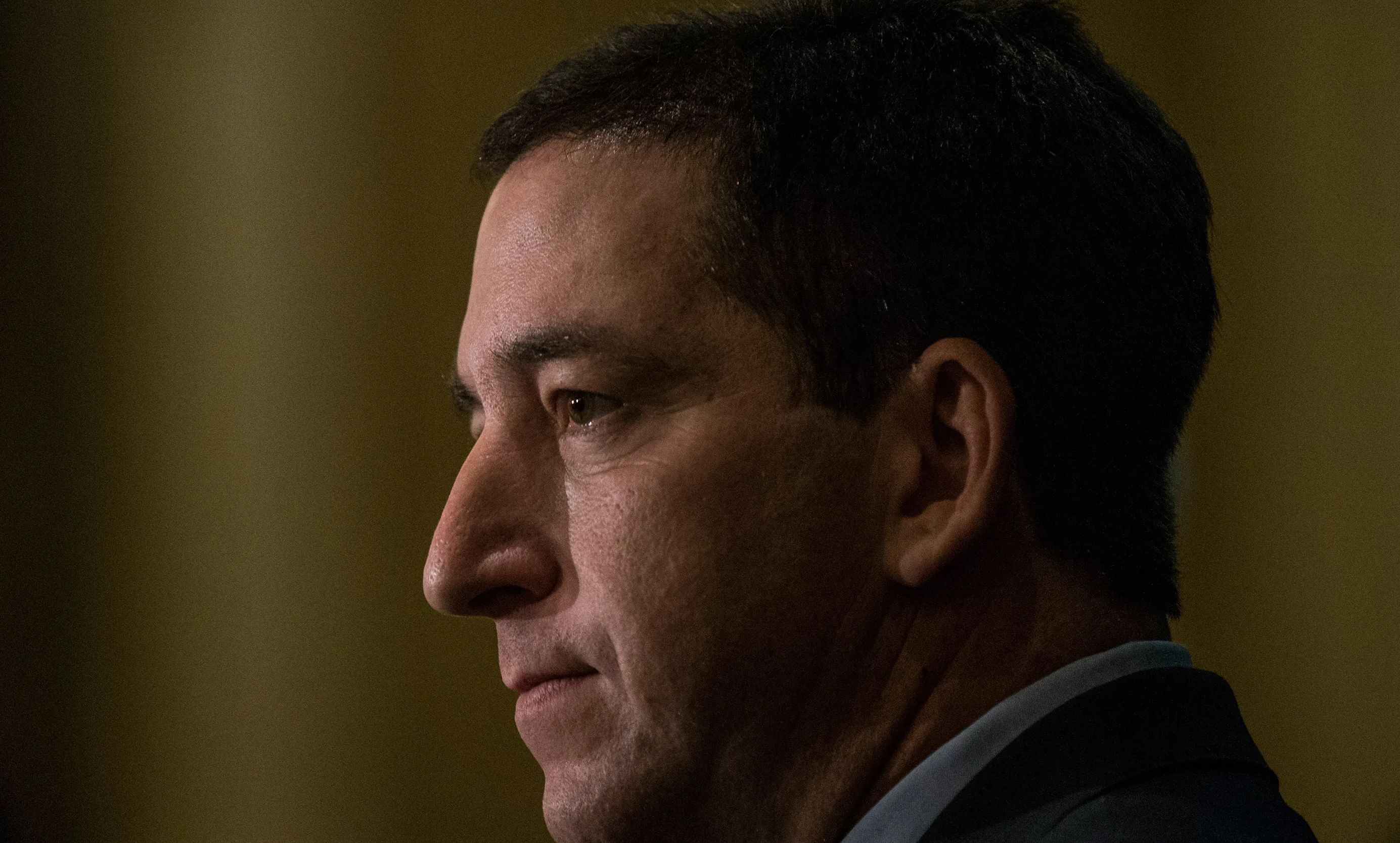 Pulitzer prize-winning reporter Glenn Greenwald looks on.