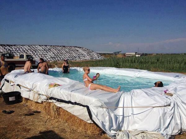 Several people enjoying the sun in a hay bale pool