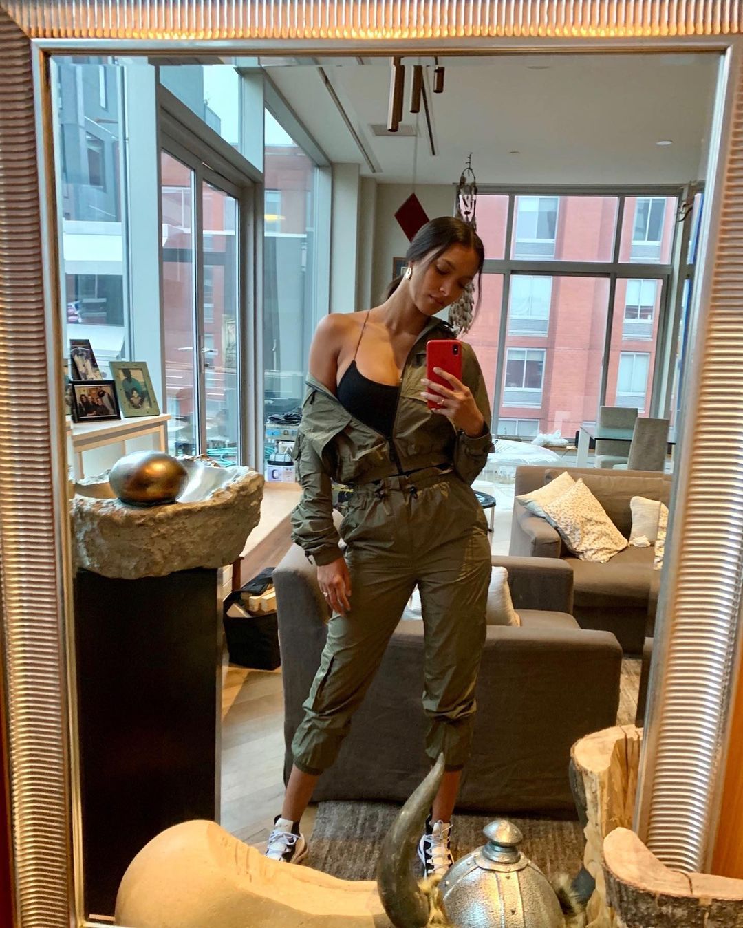 Lais Ribeiro wears khaki jumpsuit for mirror selfie.