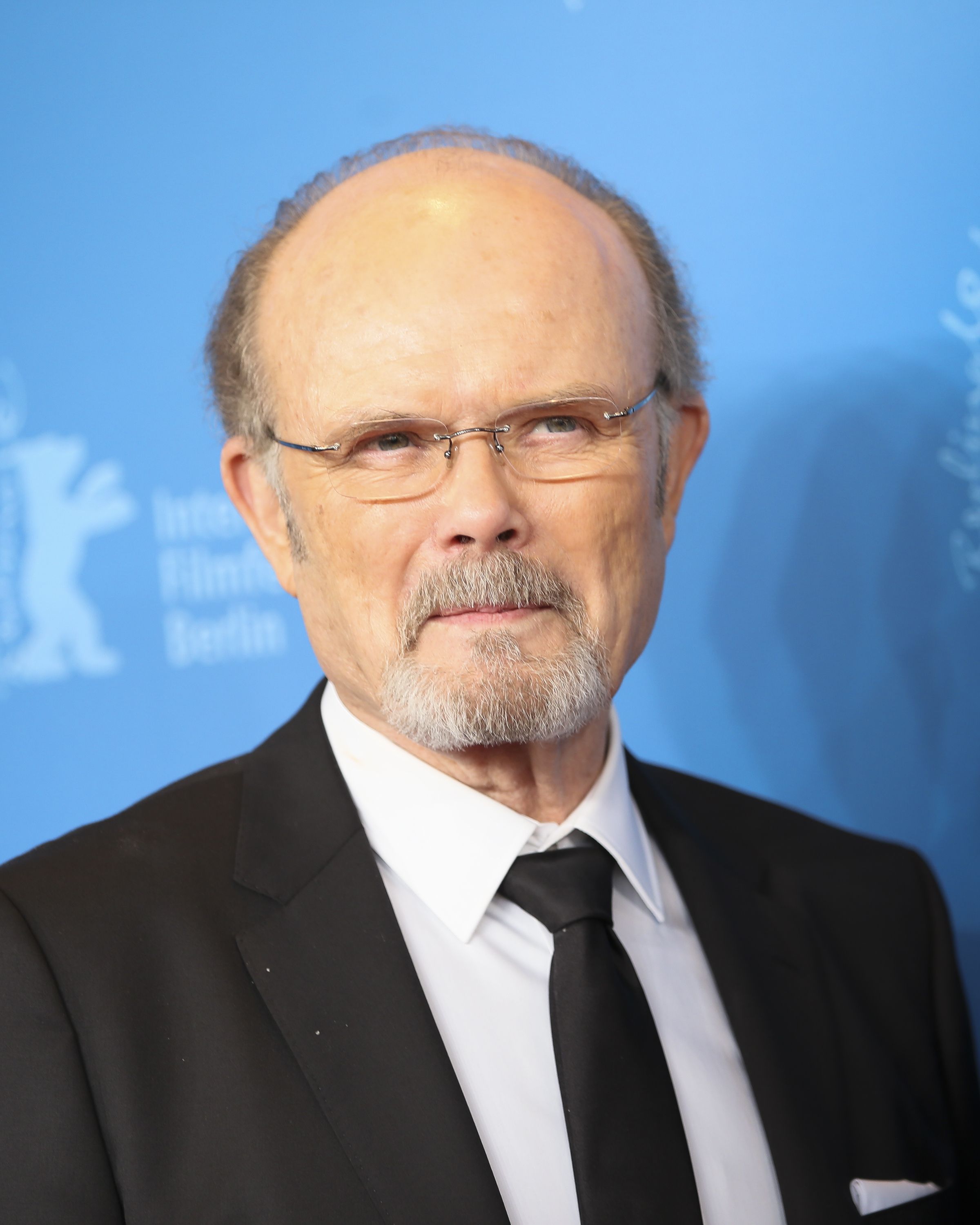 Kurtwood Smith smiles in glasses and a black suit.