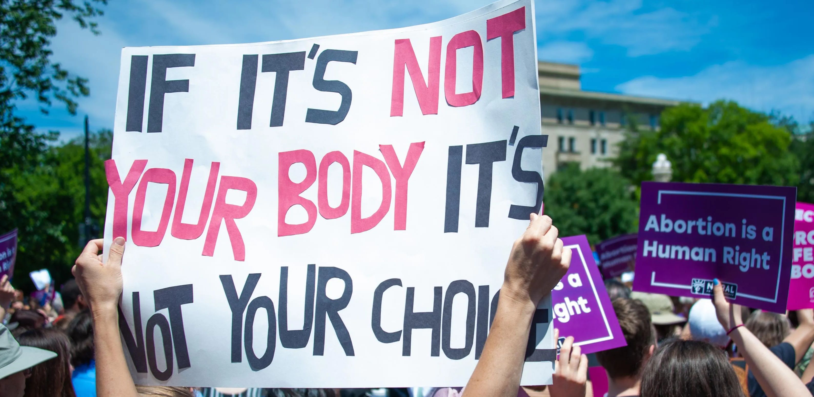Pro-choice protesters hold up banners.