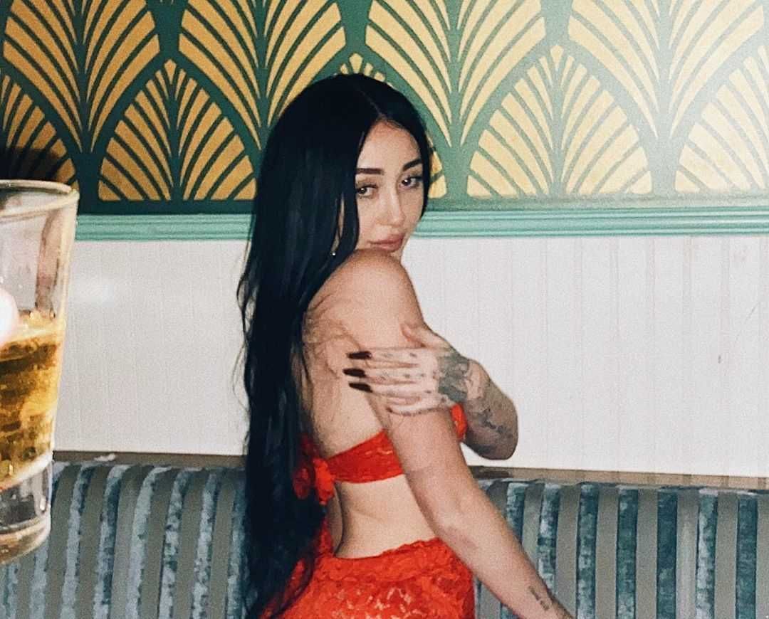 Noah Cyrus indoors in red outfit