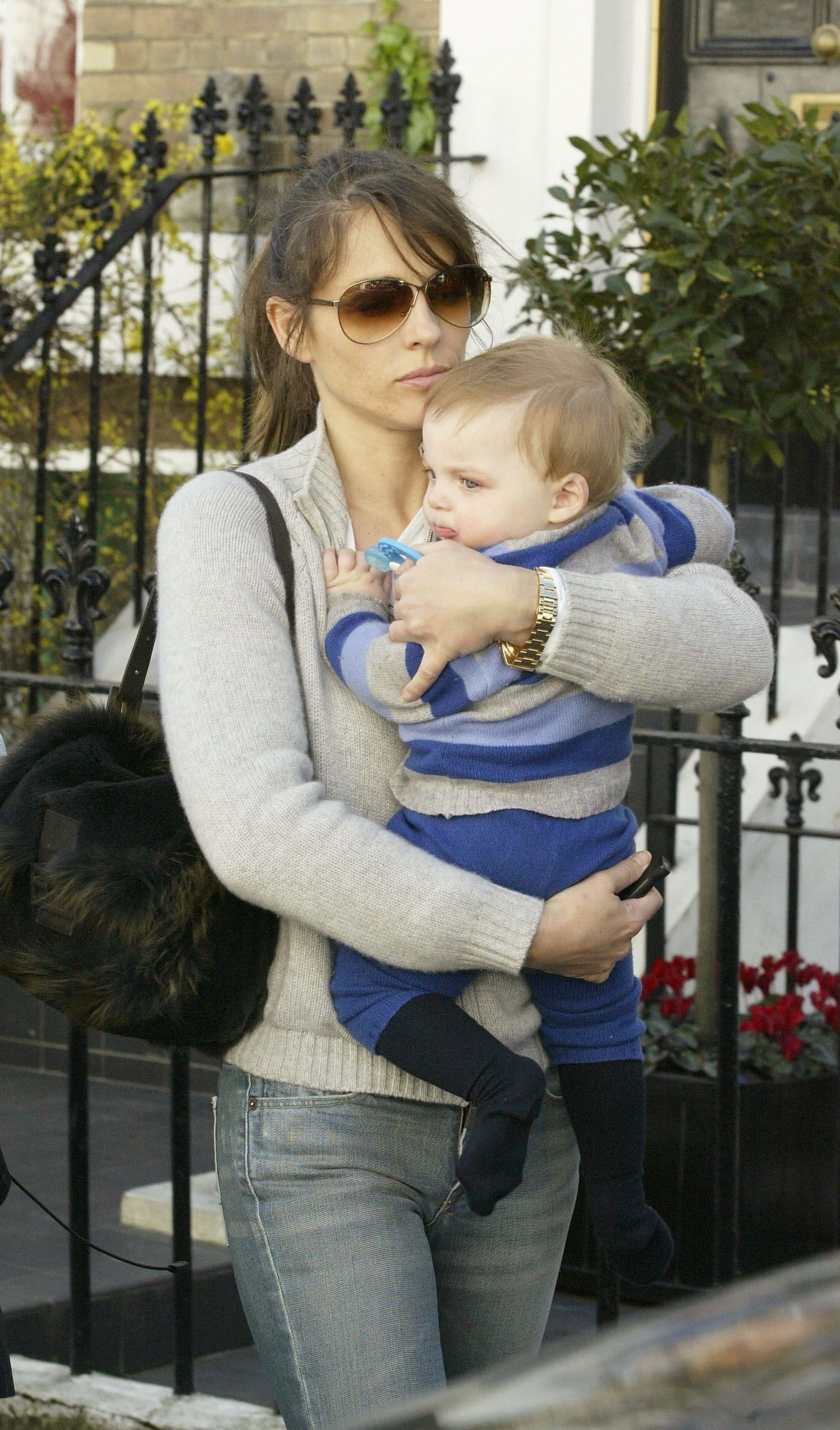 Elizabeth Hurley carrying a baby Damian in the street