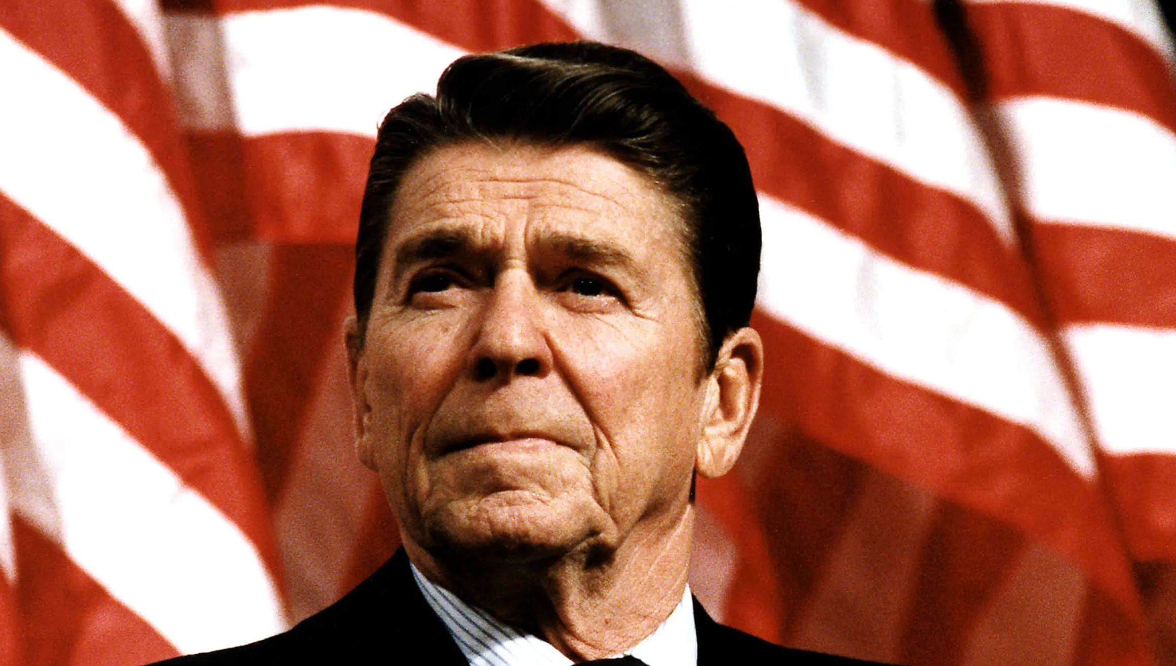 President Ronald Reagan looks on.