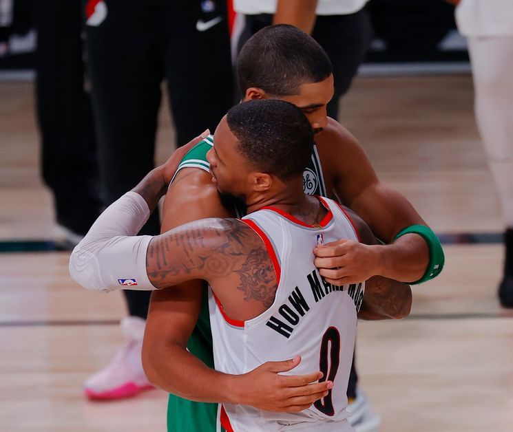 Jayson Tatum and Damian Lillard hug each other after the game