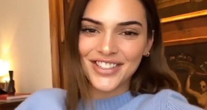 Kendall doing an IG live in a blue mock neck sweater