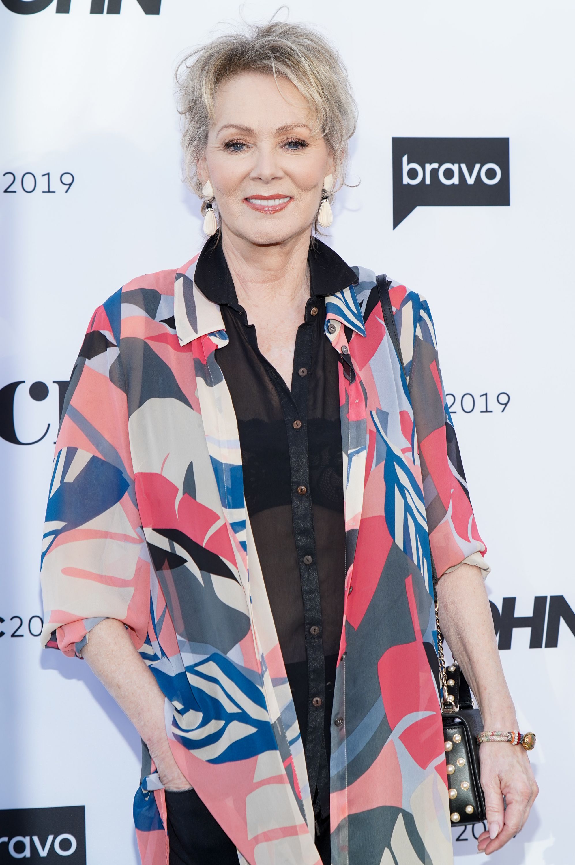 Jean Smart wears layered black and printed shirts.