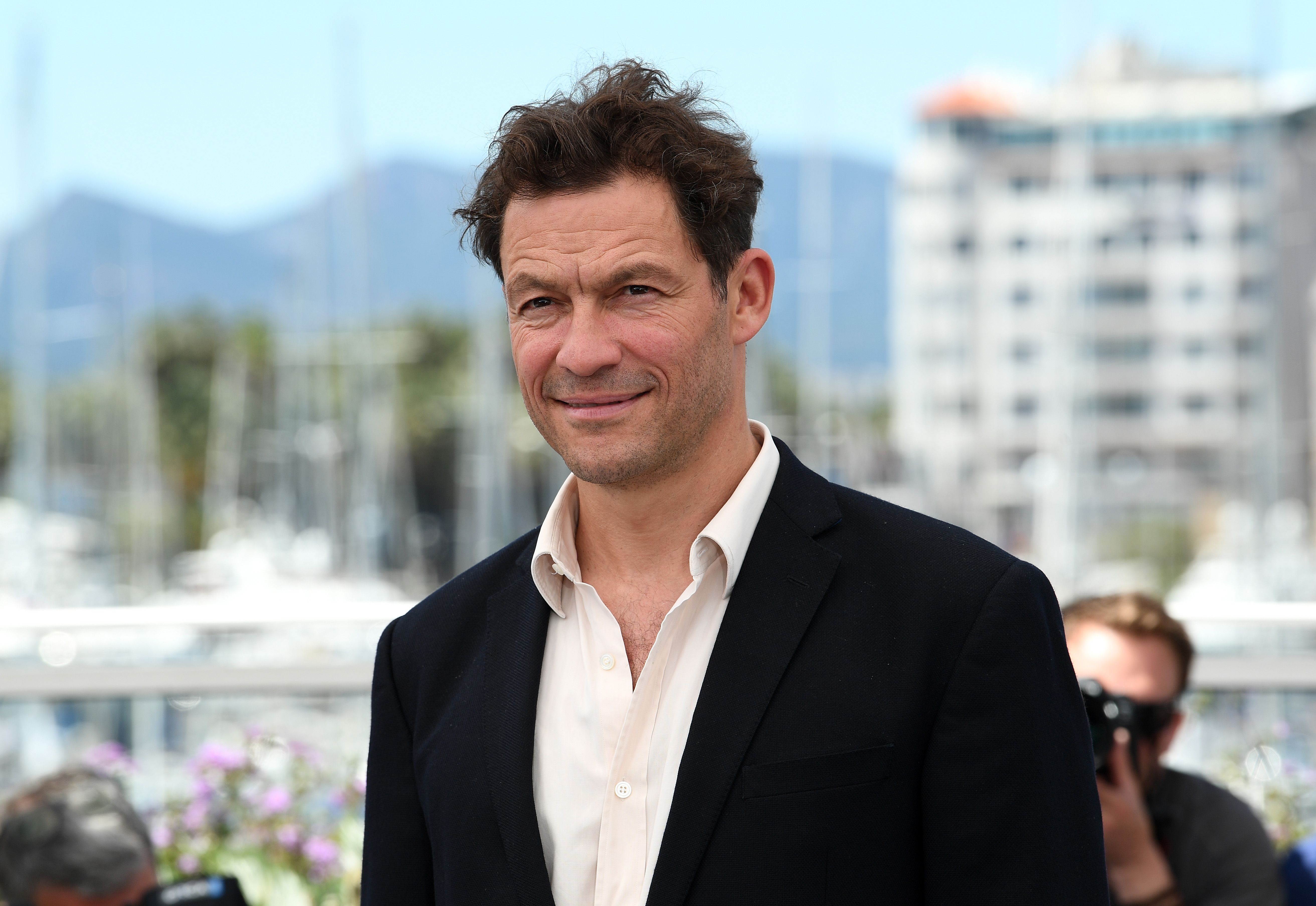 Dominic West poses in black suit at an event.