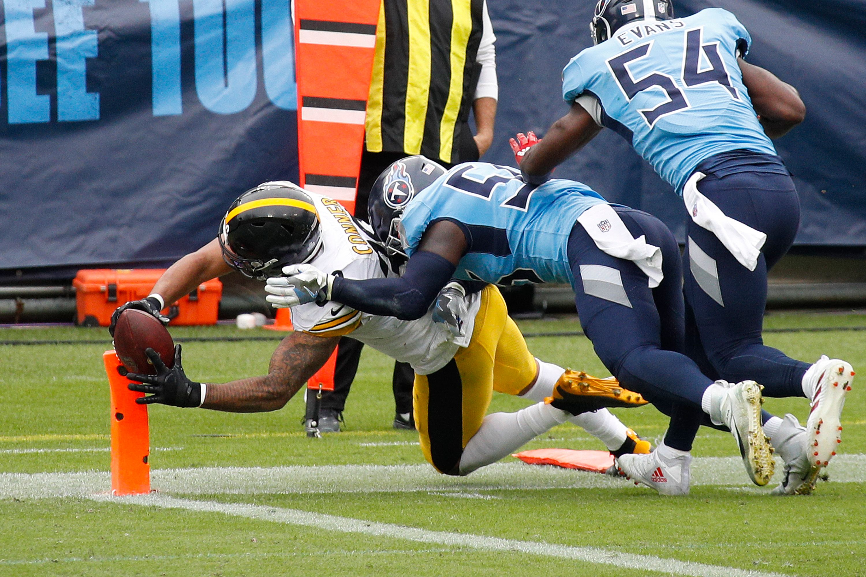 An NFL player reaches the ball over the endzone.
