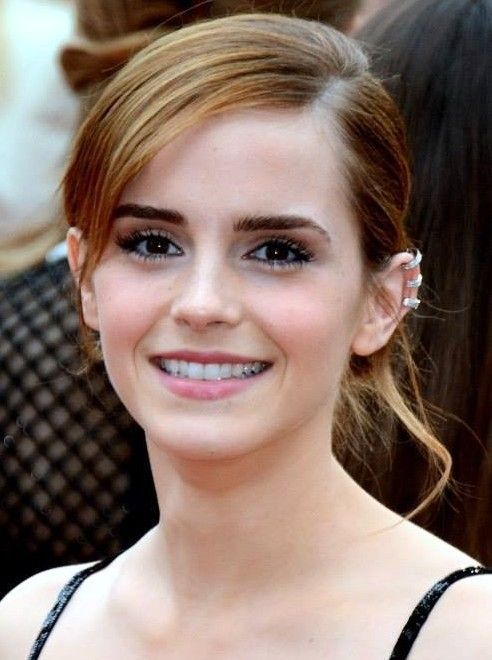 Emma Watson smiles with cuff earrings.
