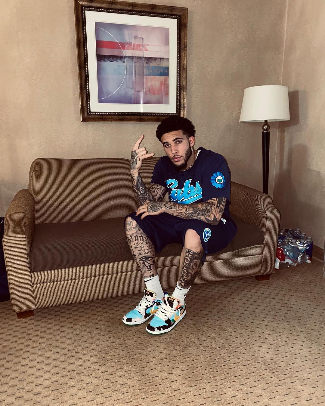 LiAngelo Ball sitting on a couch in a hotel room.