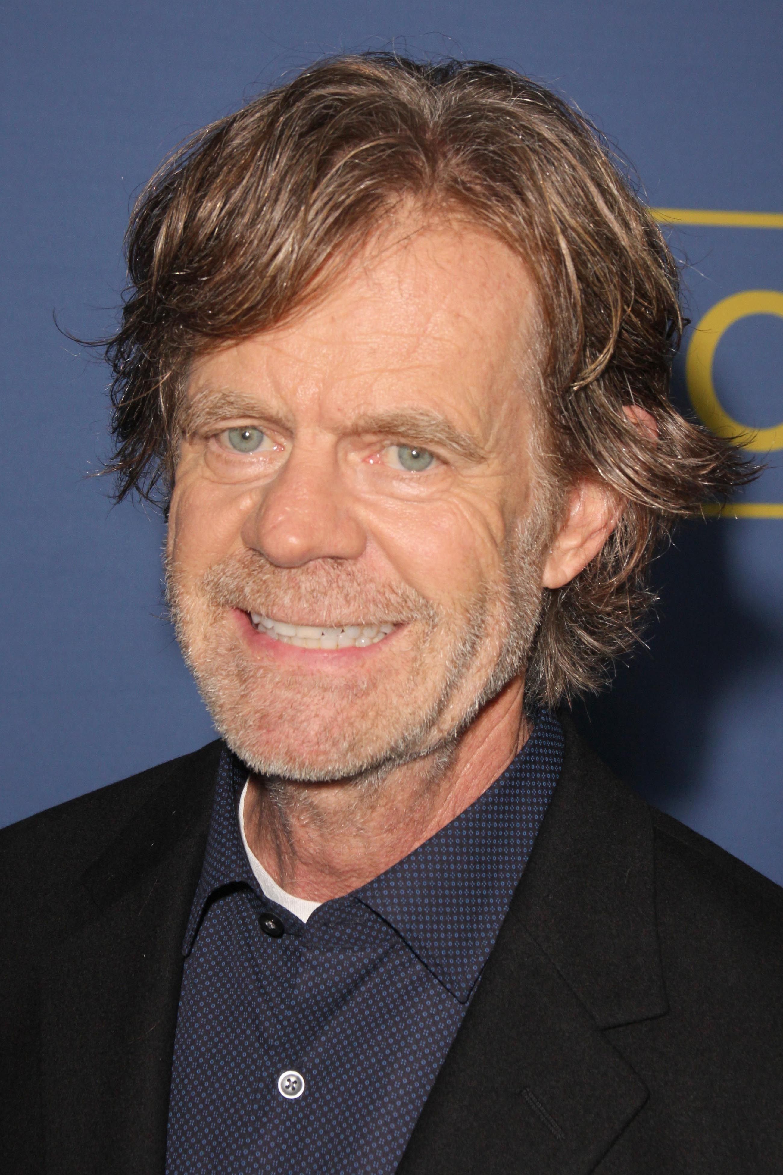 William H. Macy wears a button-up and black blazer.