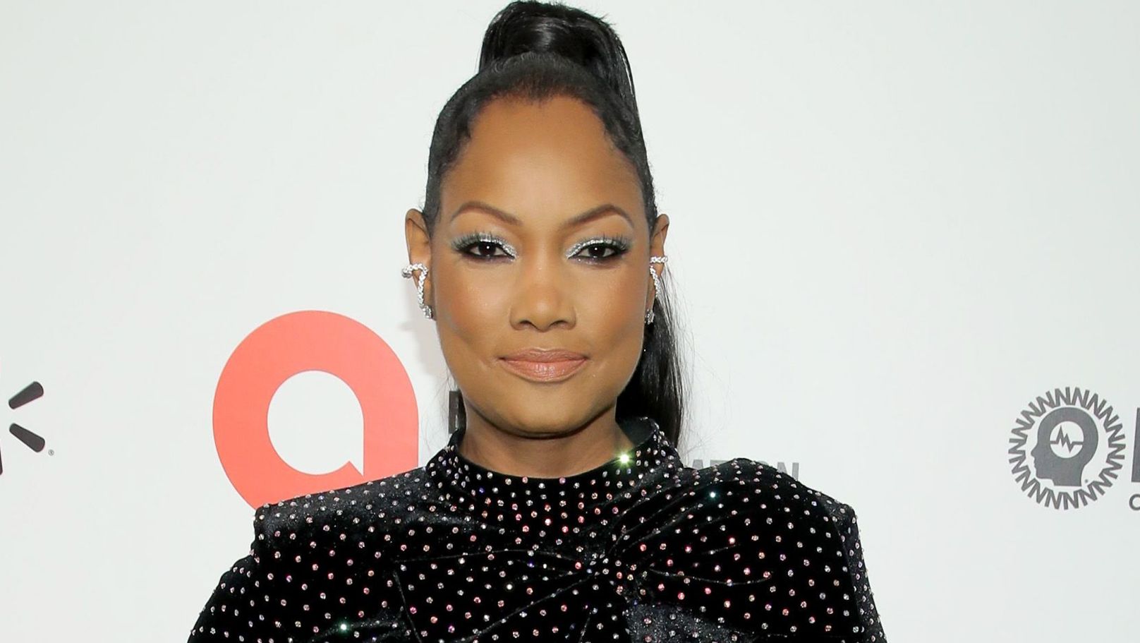 Garcelle Beauvais wears a high ponytail and metallic eyeshadow.