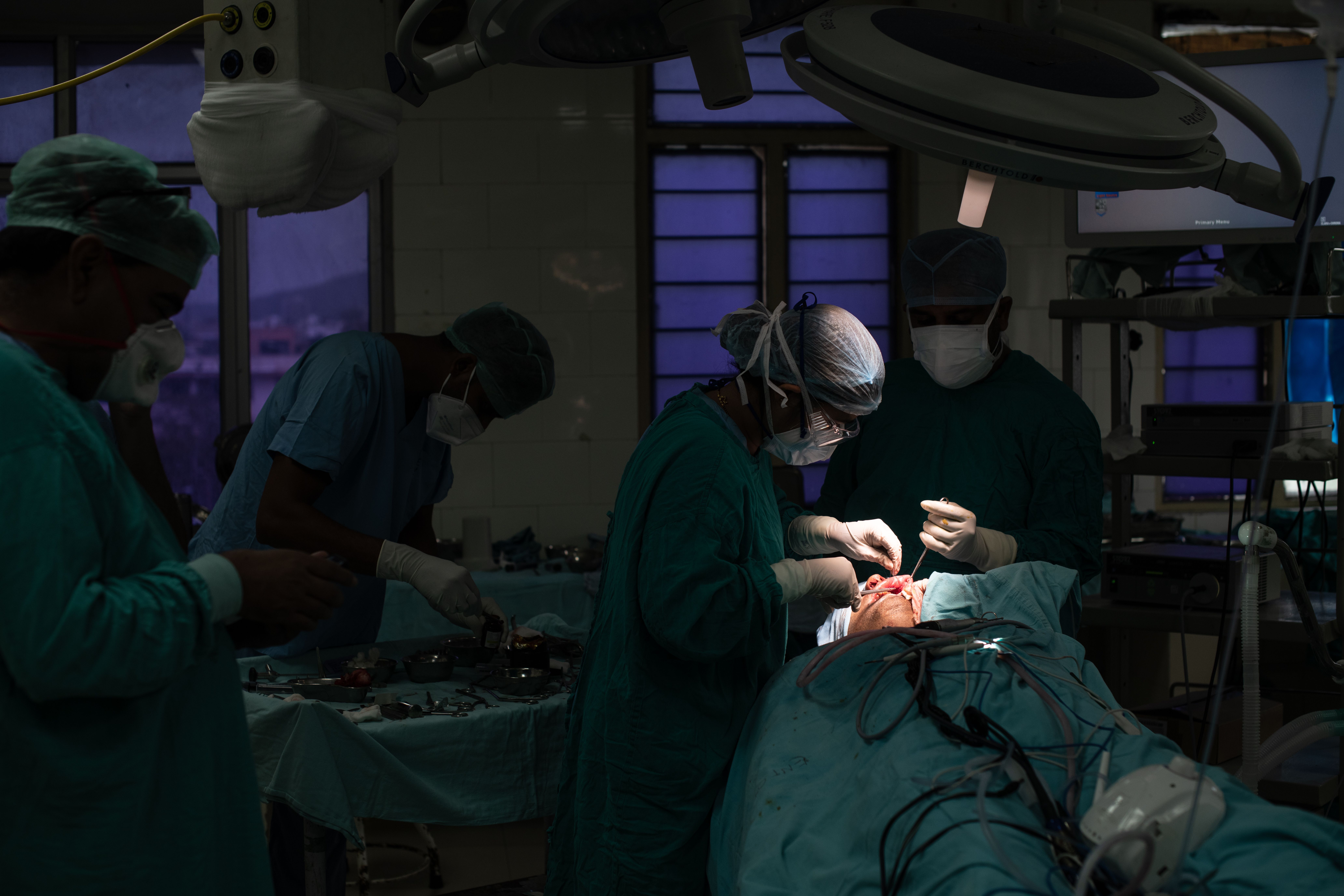 Surgeons perform a facial operation on a patient.