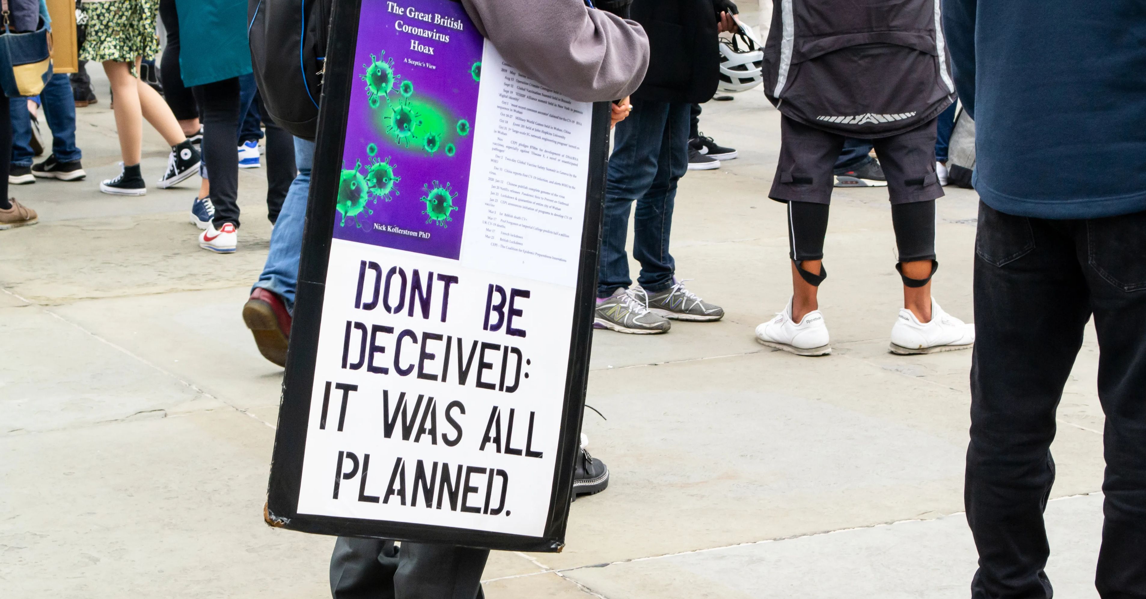 Protester holds a sign claiming coronavirus isn't real.