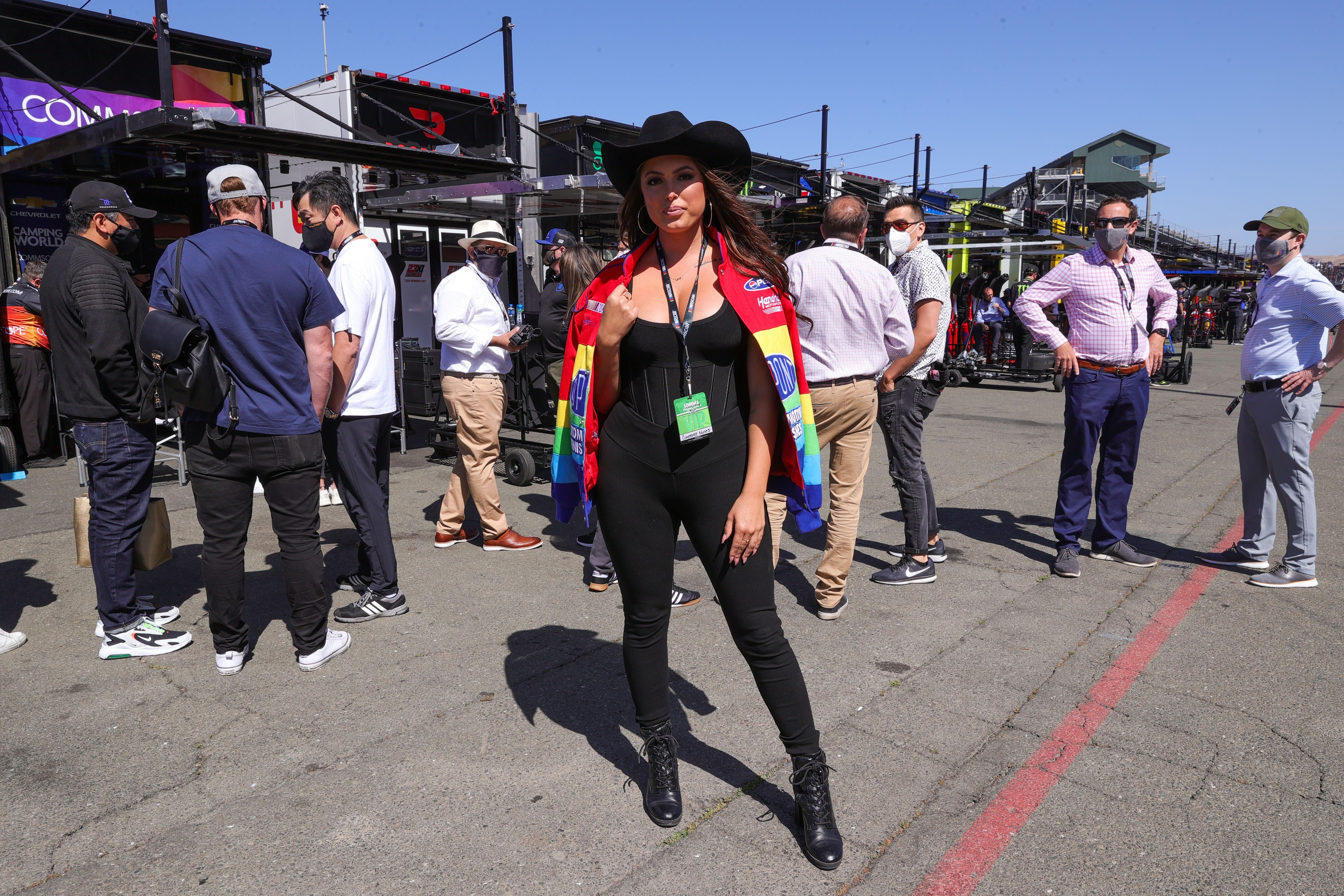Constance Nunes wears a black jumpsuit and boots with a cowboy hat.