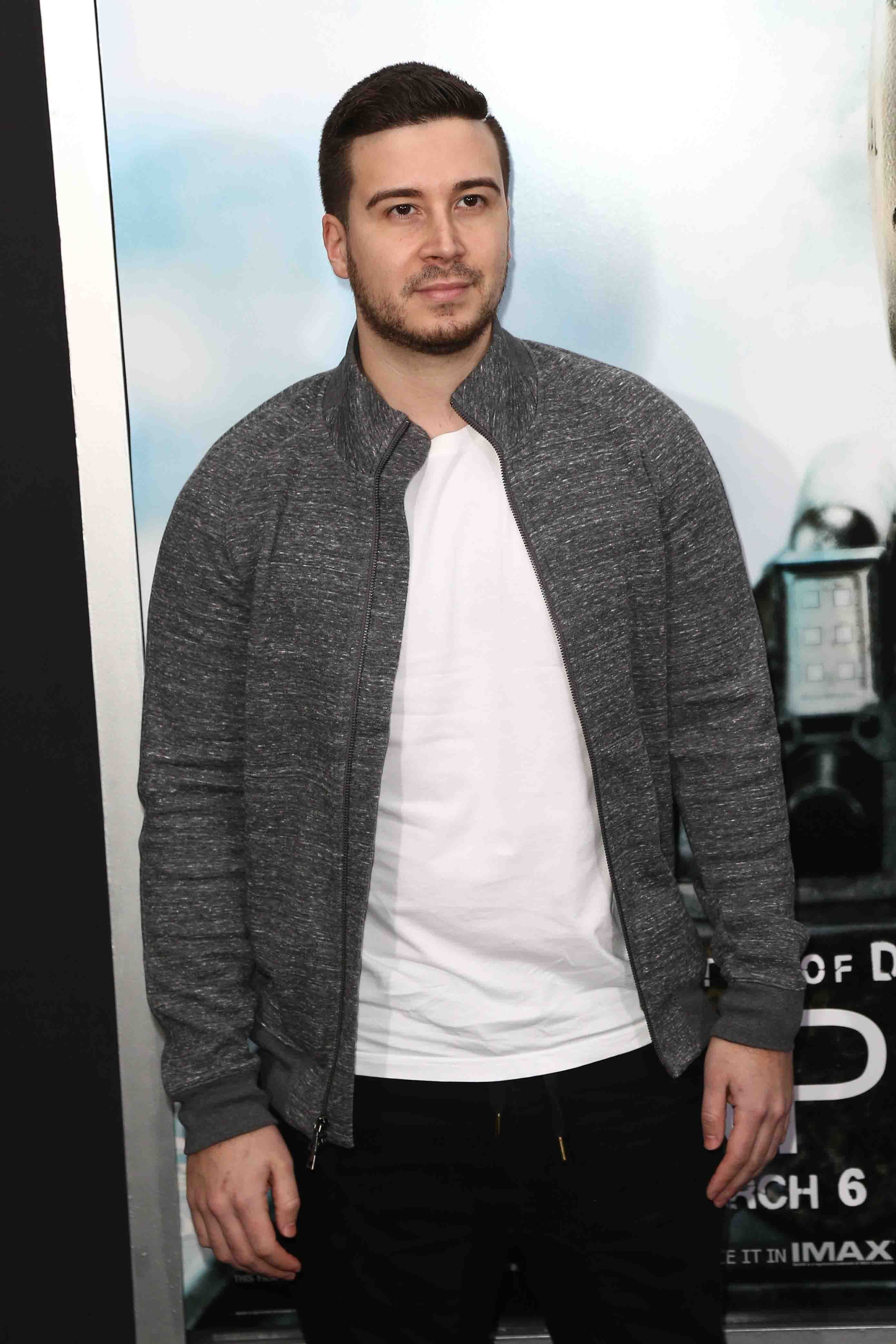 Vinny Guadagnino wears a black jacket and white T-shirt.