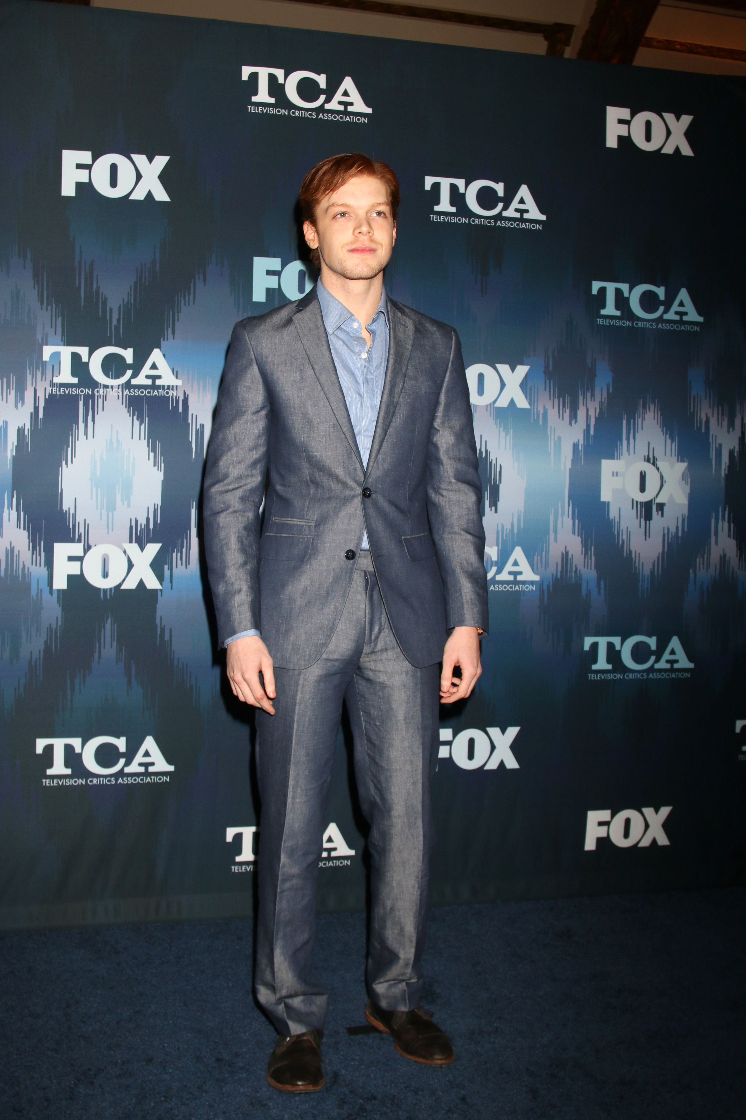 Cameron Monaghan wears a blue suit and pants.