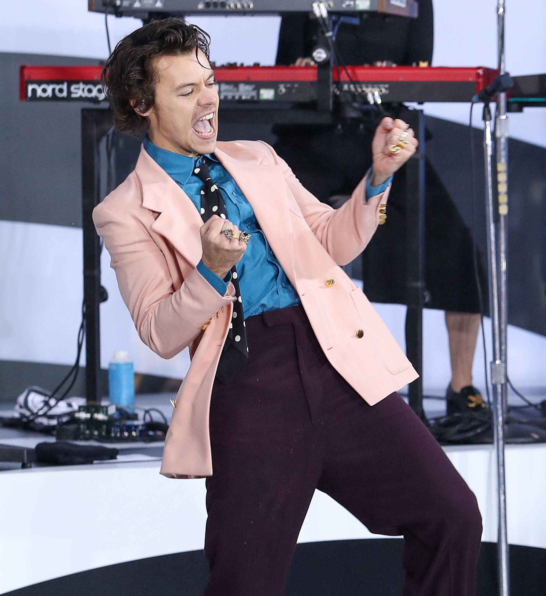 Harry Styles in a jacket on stage