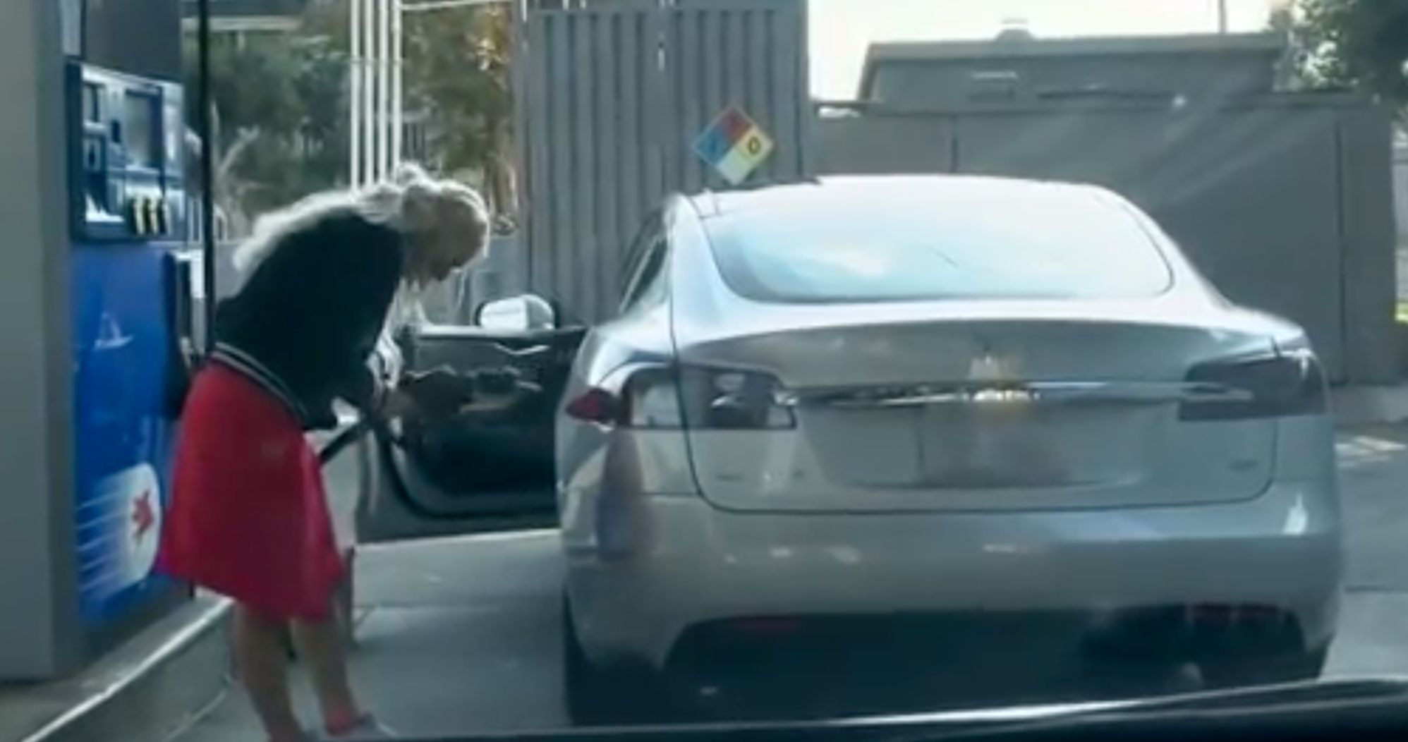 blonde tries to put gasoline in a tesla s